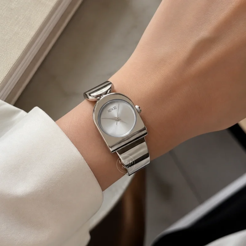 This stunning ladies' watch features a sleek silver-tone arched case paired with a clean, minimalist silver dial. Designed with a high-polish silver bangle band, it offers a perfect balance of modern elegance and chic style. Designed for women who love trendy, contemporary accessories, this versatile everyday watch adds a cool, polished touch to any outfit. It serves as an eye-catching bracelet watch for both daily wear and special occasions.