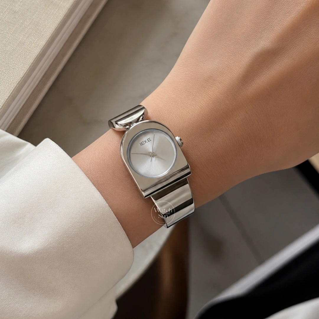 This stunning ladies' watch features a sleek silver-tone arched case paired with a clean, minimalist silver dial. Designed with a high-polish silver bangle band, it offers a perfect balance of modern elegance and chic style. Designed for women who love trendy, contemporary accessories, this versatile everyday watch adds a cool, polished touch to any outfit. It serves as an eye-catching bracelet watch for both daily wear and special occasions.