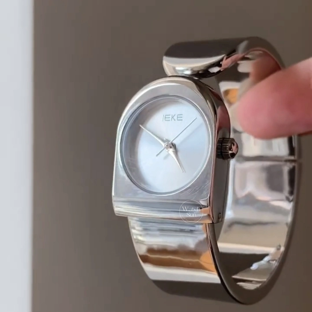 This stunning ladies' watch features a sleek silver-tone arched case paired with a clean, minimalist silver dial. Designed with a high-polish silver bangle band, it offers a perfect balance of modern elegance and chic style. Designed for women who love trendy, contemporary accessories, this versatile everyday watch adds a cool, polished touch to any outfit. It serves as an eye-catching bracelet watch for both daily wear and special occasions.