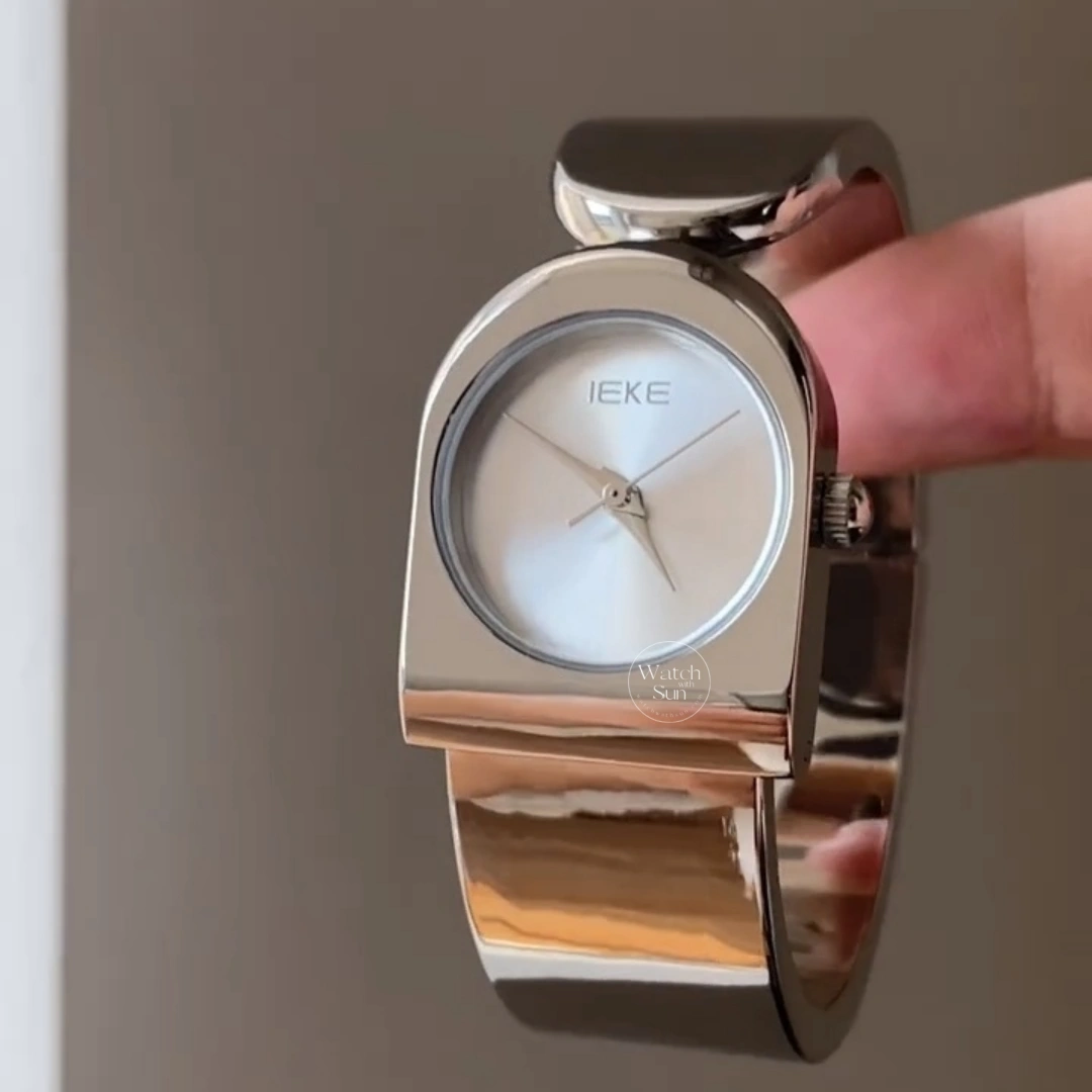 This stunning ladies' watch features a sleek silver-tone arched case paired with a clean, minimalist silver dial. Designed with a high-polish silver bangle band, it offers a perfect balance of modern elegance and chic style. Designed for women who love trendy, contemporary accessories, this versatile everyday watch adds a cool, polished touch to any outfit. It serves as an eye-catching bracelet watch for both daily wear and special occasions.